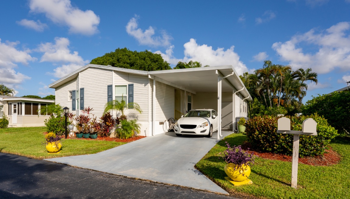 Photo of a mobile home in a trailer park with car in driveway