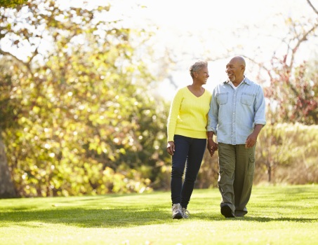 Senior Couple Walking Through Autumn Woodland